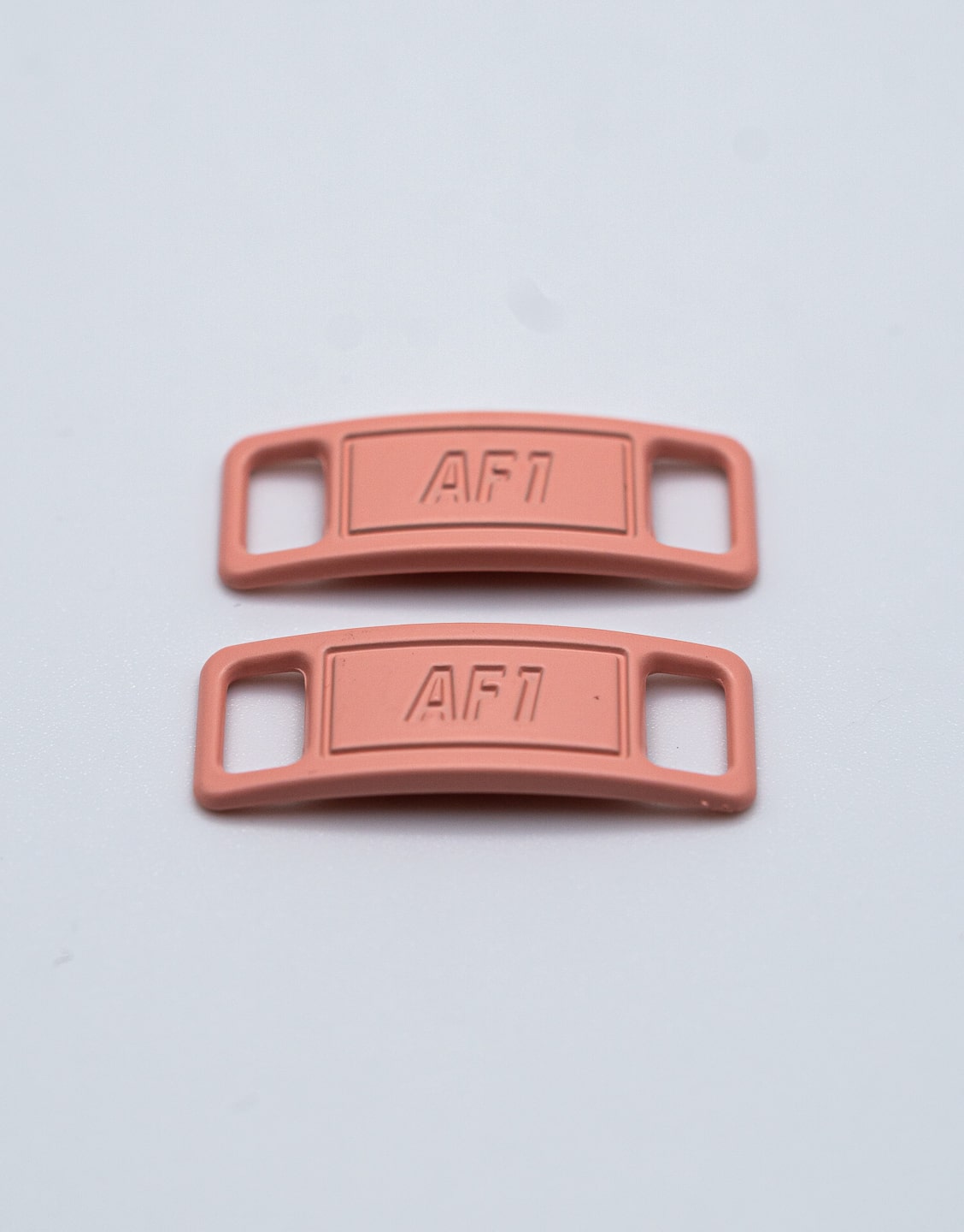 Hebillas metálicas rosa salmón para decorar los cordones y personalizar unas zapatillas. Hebillas rosa salmón para cordones de zapatillas