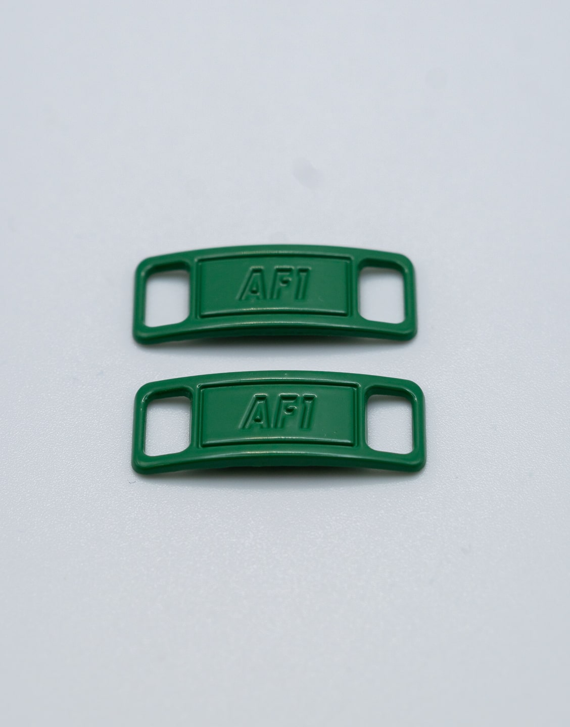 Hebillas metálicas verde botella para decorar y personalizar los cordones de unas zapatillas. Hebillas verde botella para cordones de zapatillas
