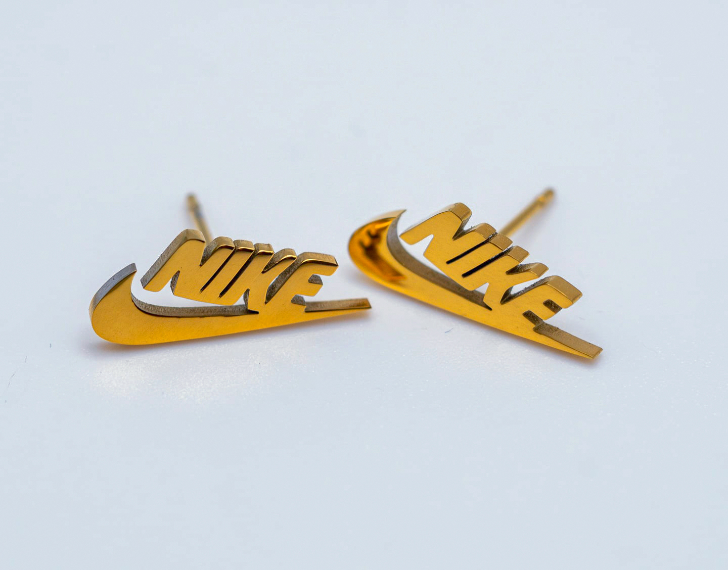 Pendientes Mini Swoosh y letras Nike dorados