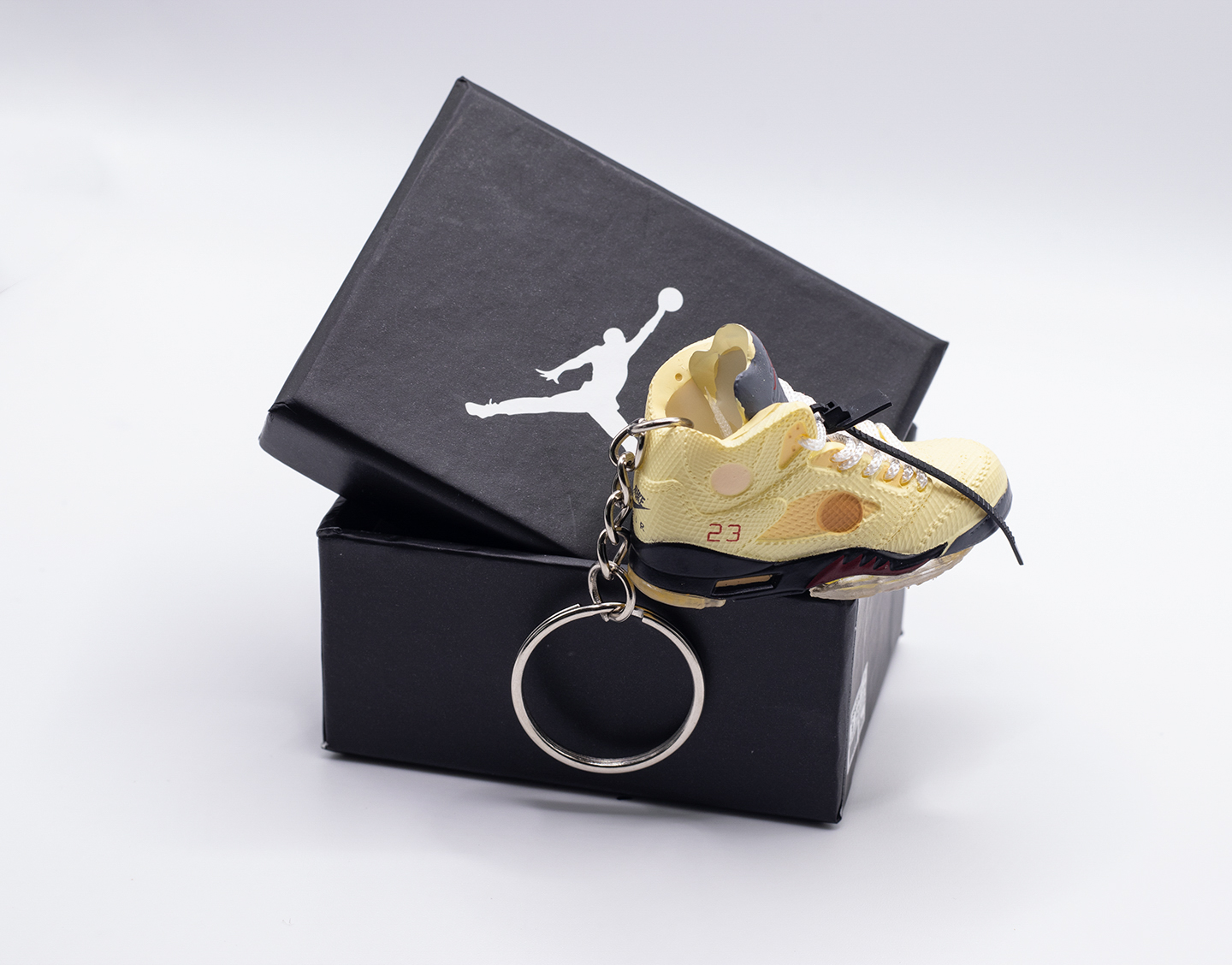 Mini llavero Air Jordan 5 Off-White Sail junto a su caja abierta